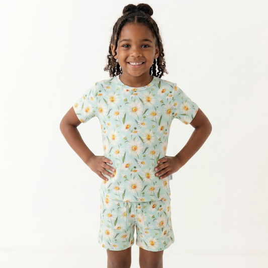 Child wearing a floral pajama set on a white background
