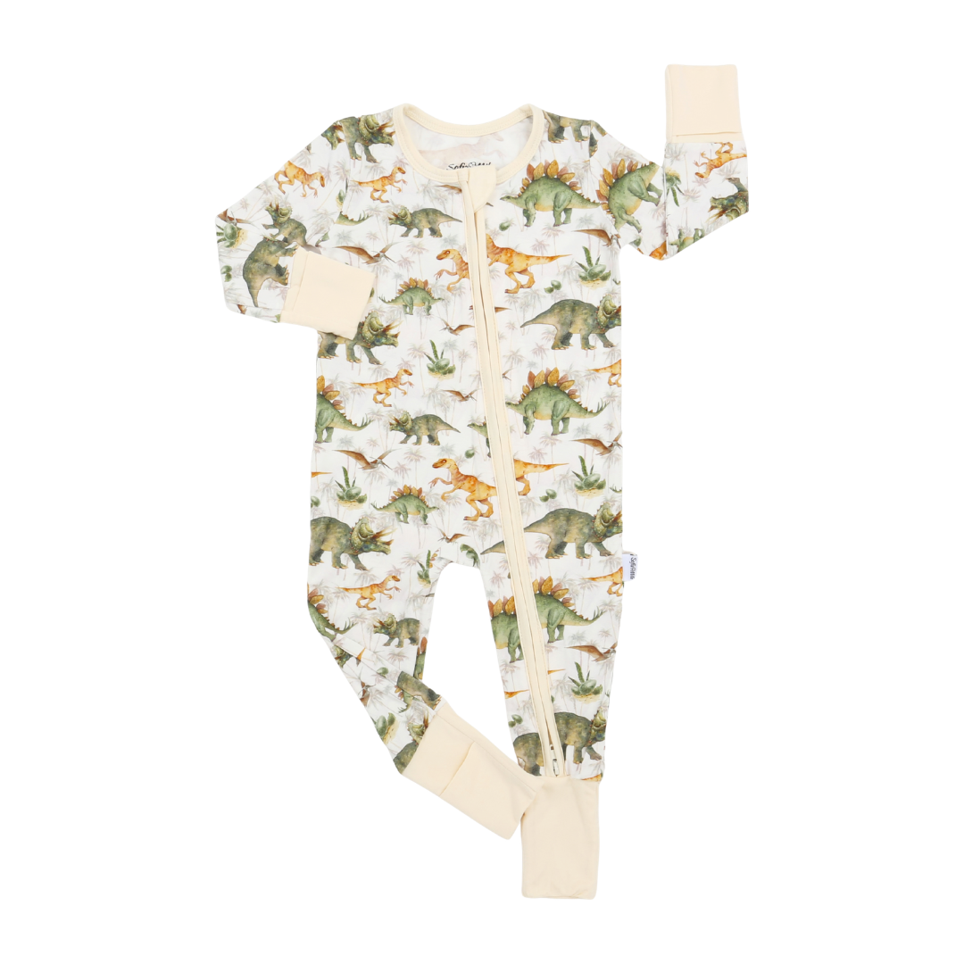 A baby long-sleeve footed sleeper with an all-over dinosaur print on a cream background, featuring beige cuffs and footies.
