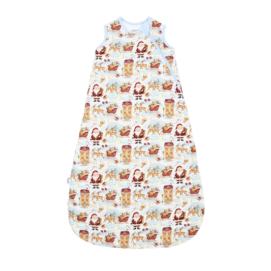 A baby sleep sack with a festive Santa Claus and reindeer print on a white background, featuring a light blue collar and shoulder straps.
