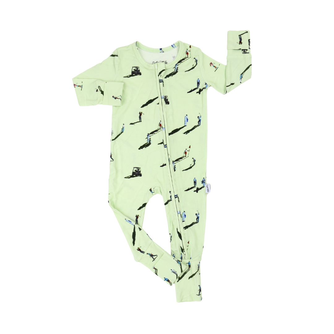 A light green long-sleeve baby footed sleeper with an all-over print of skaters, photographed flat on a white background.