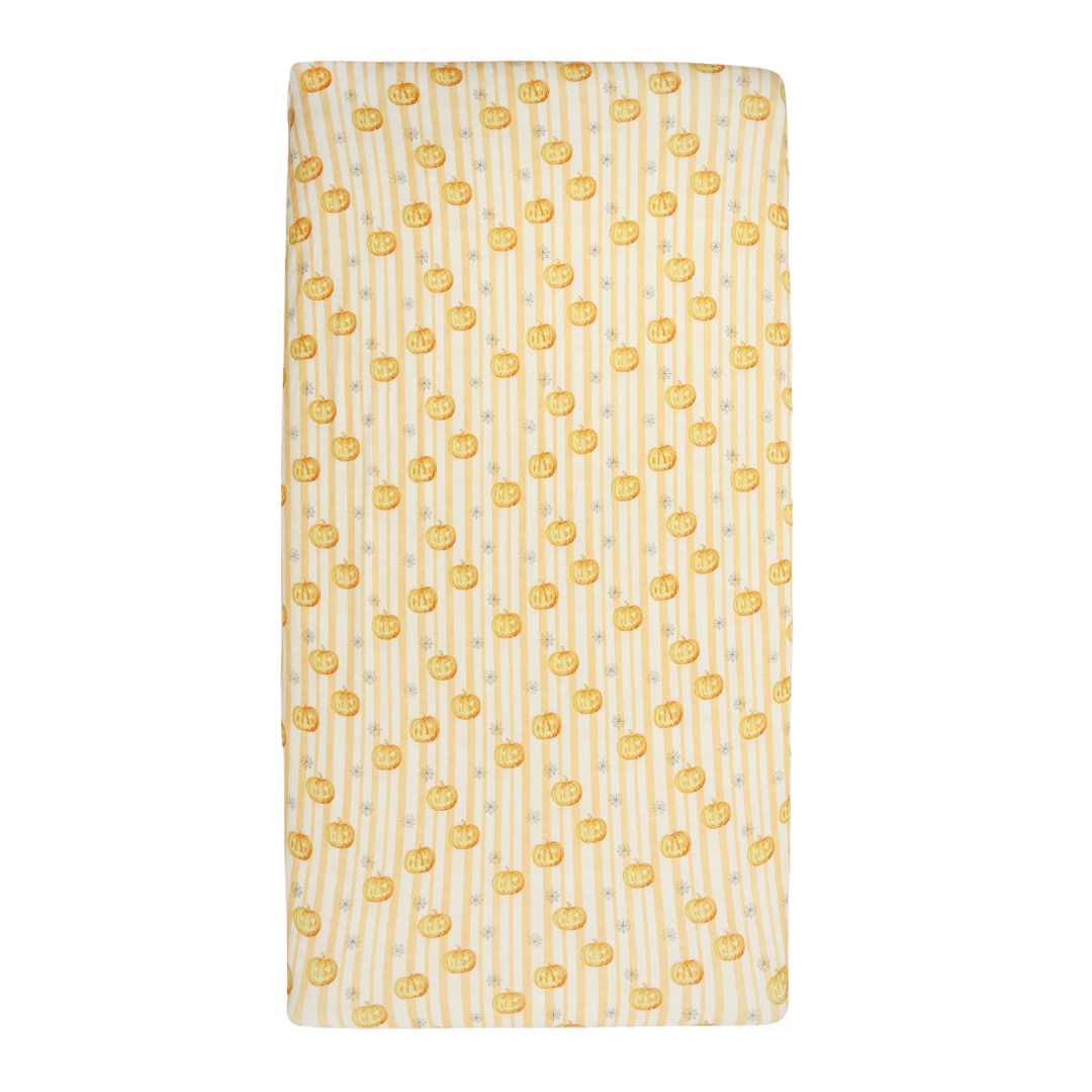 A rectangular baby blanket with a pattern of small yellow smiley faces on a white background with vertical yellow stripes.