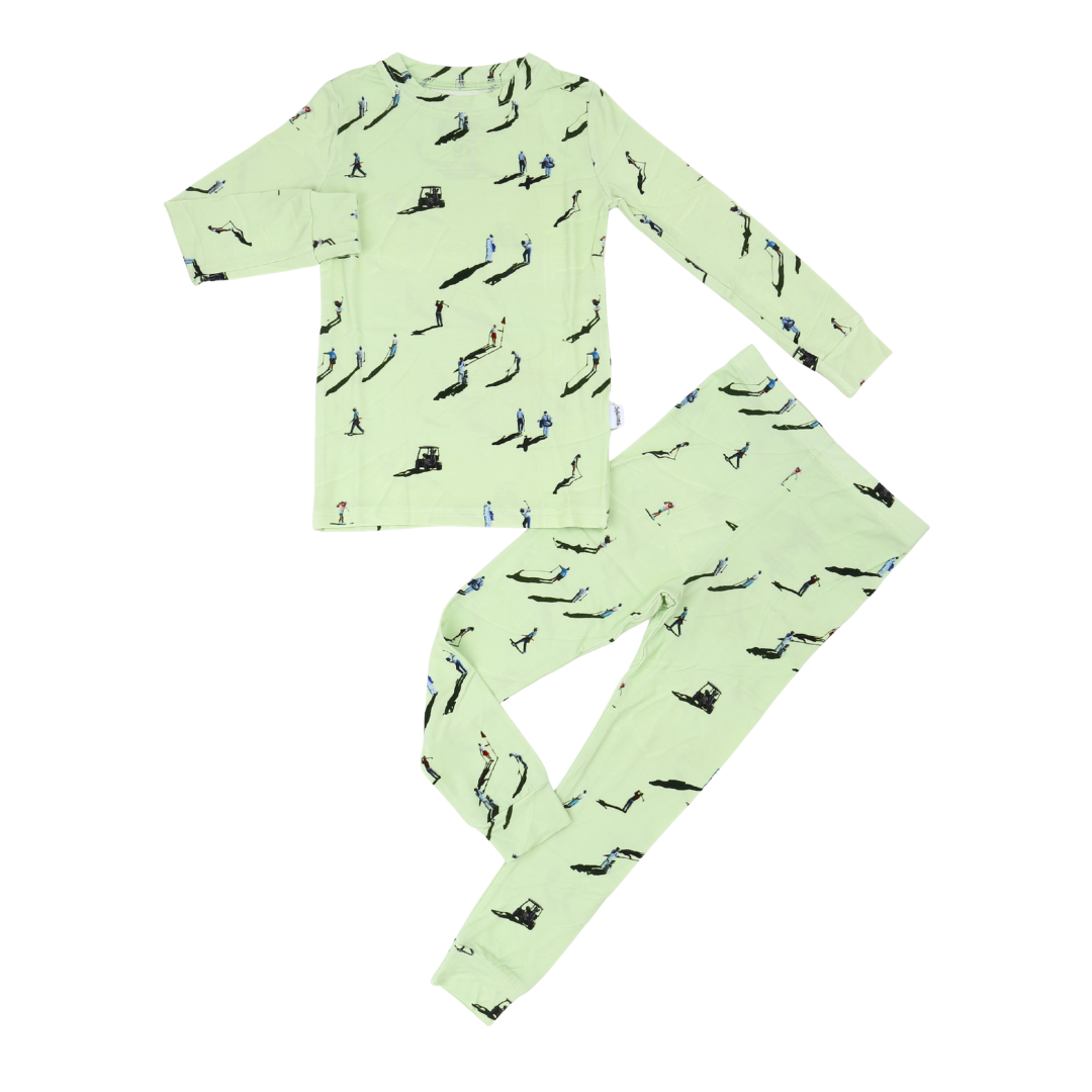 A two-piece children's pajama set consisting of a long-sleeve top and matching pants in light green, both featuring an all-over black and blue bird print, laid flat on a white background.