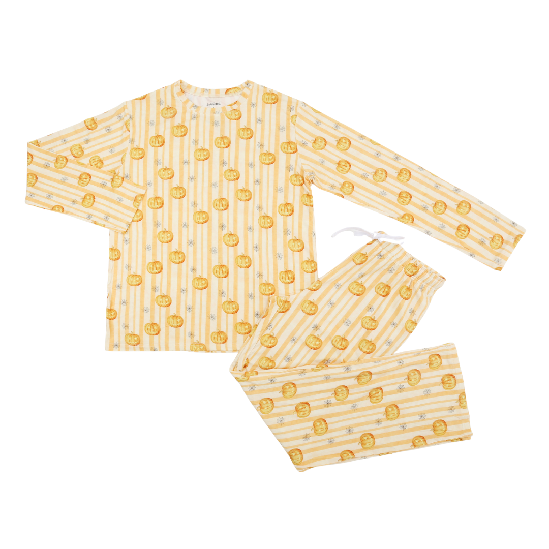 A two-piece children's pajama set featuring a long-sleeve top and matching pants. The fabric has a pale yellow and white vertical stripe pattern with a repeating motif of orange jack-o'-lantern pumpkins, and a small white drawstring is visible at the collar.