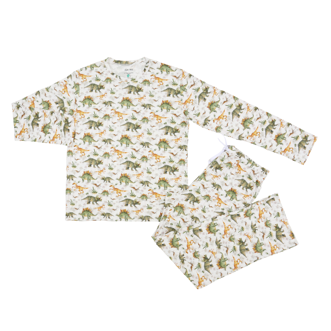 A two-piece children's pajama set featuring a long-sleeve top and matching pants with an all-over dinosaur print on an off-white background.