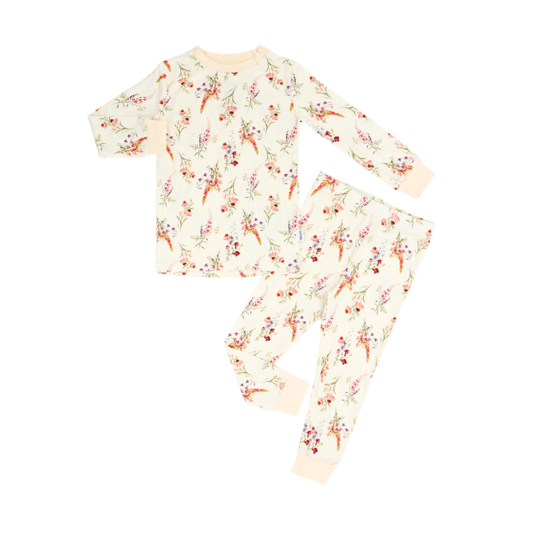 A two-piece long-sleeve pajama set featuring a cream-colored base with a delicate all-over floral and bird print in red, orange, and green, laid flat on a white background.