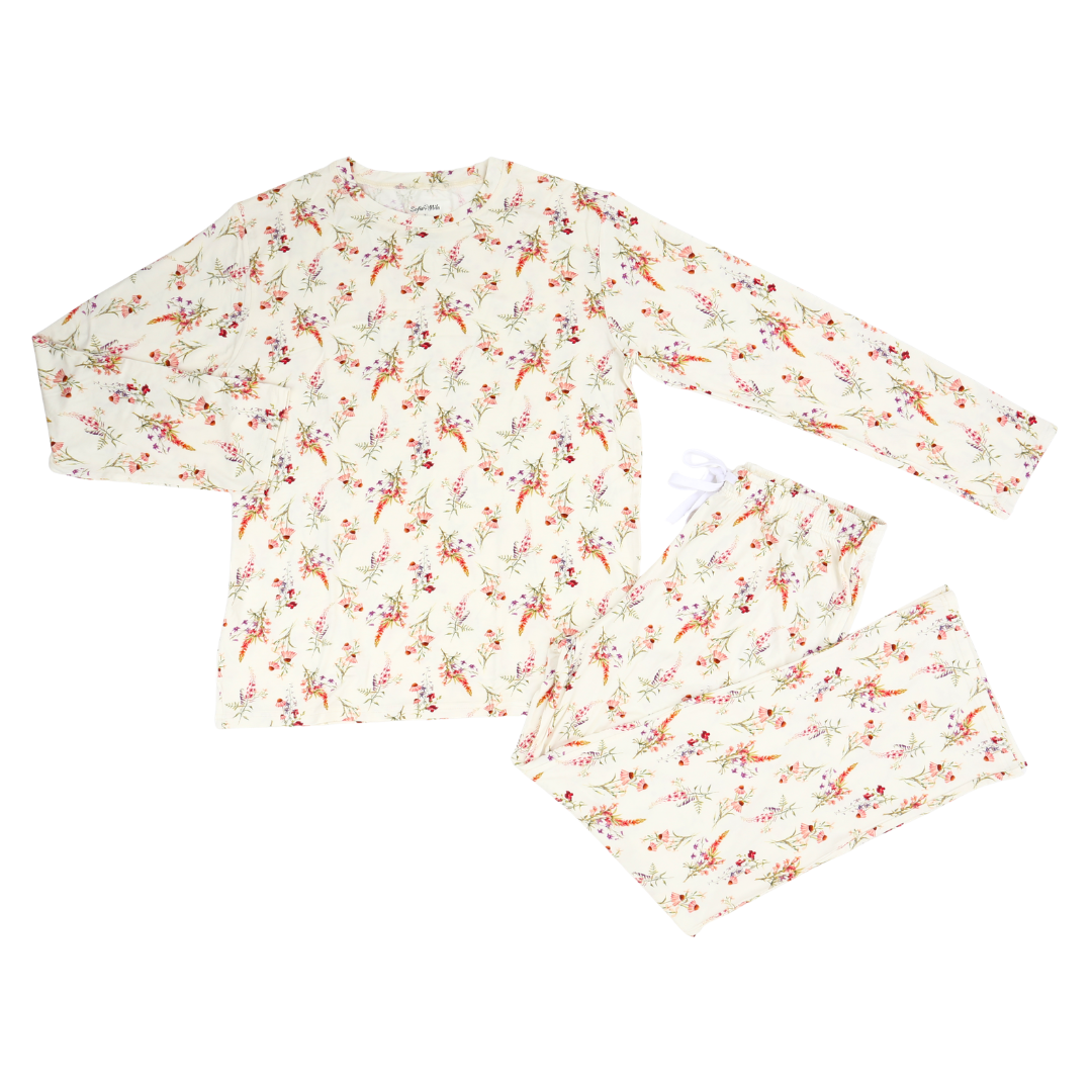 A two-piece long-sleeve pajama set featuring a cream-colored fabric with an all-over delicate floral and berry print in muted red, orange, and green tones, laid flat on a white background.