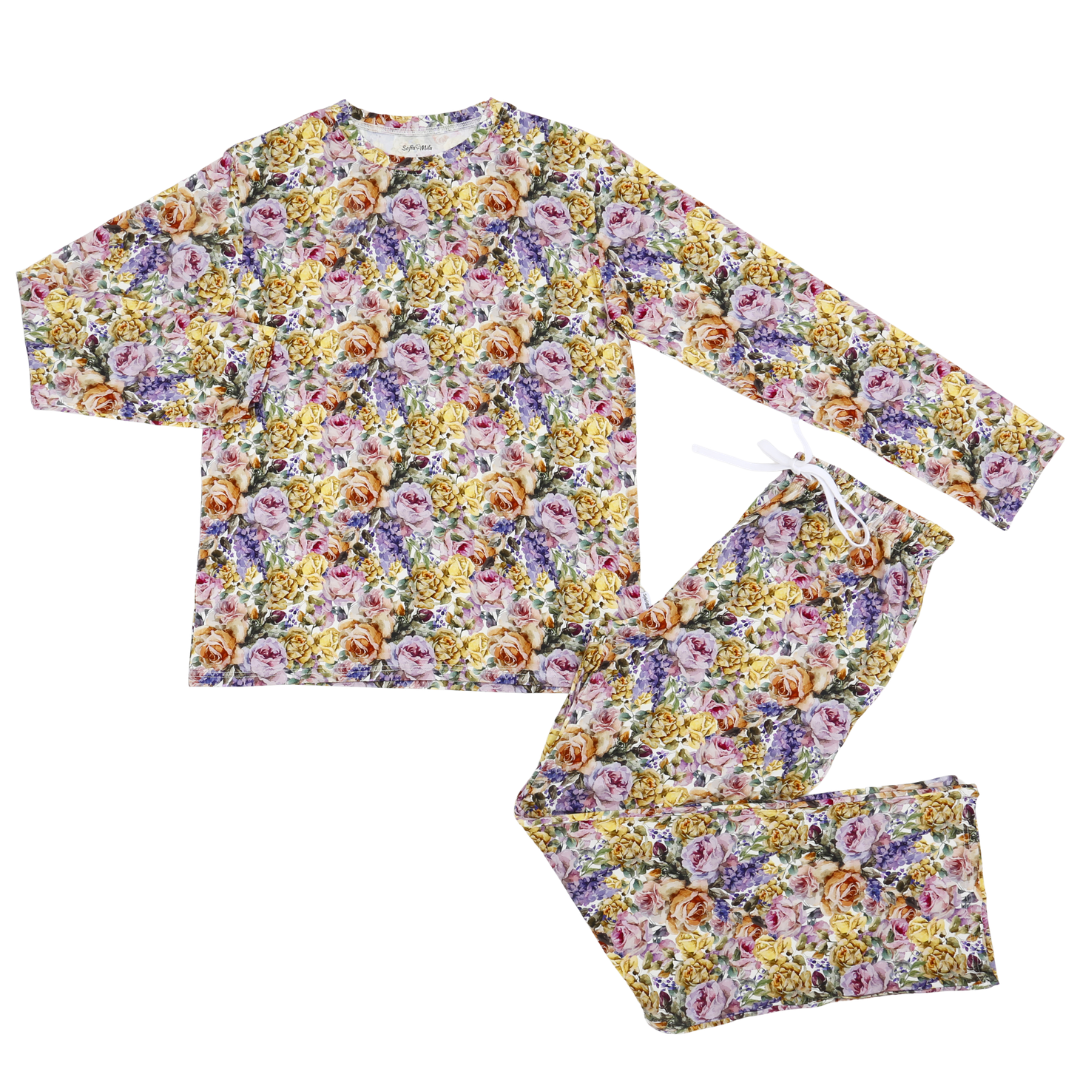 A two-piece pajama set featuring a long-sleeve top and matching pants with an all-over floral print in shades of purple, yellow, orange, and green on a light background.