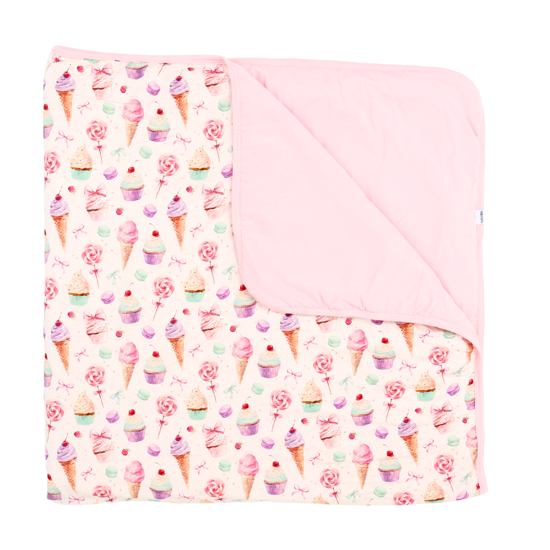 Baby blanket with ice cream cone and cupcake pattern on a white background