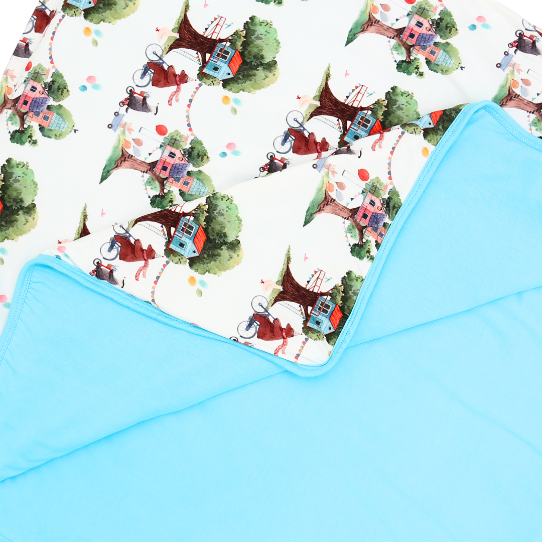 Children's blanket with cartoon train and tree pattern on a white background