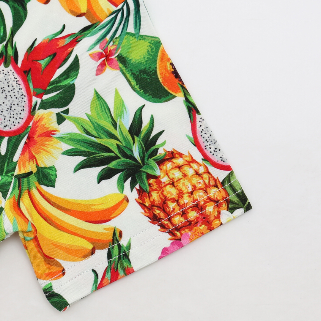Fabric with tropical fruit pattern including pineapple, banana, dragon fruit, and papaya on a white background.