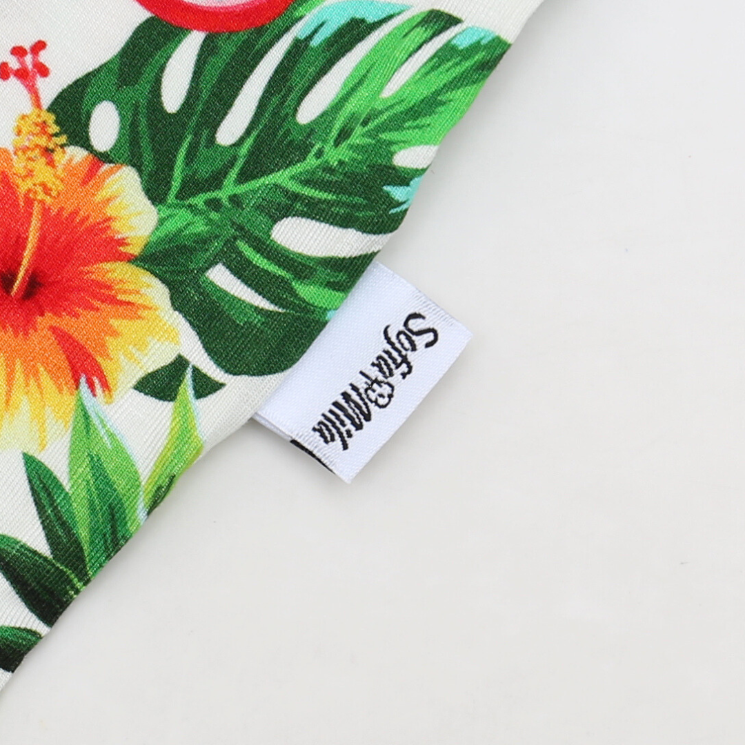 Fabric with tropical floral design and a visible brand label on a white background