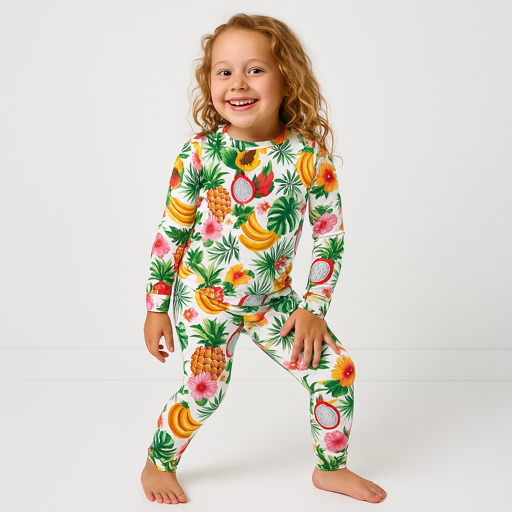 Child wearing a colorful fruit-patterned onesie on a white background