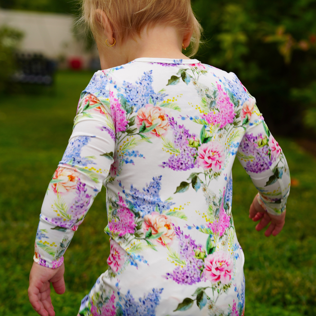 Child wearing a floral patterned shirt outdoors.