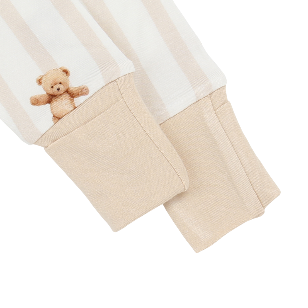Beige pants with a teddy bear patch on a white background