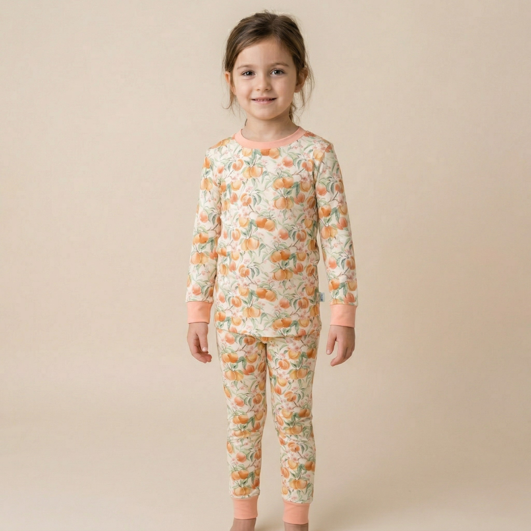 Child wearing a pajama set with a peach pattern on a beige background