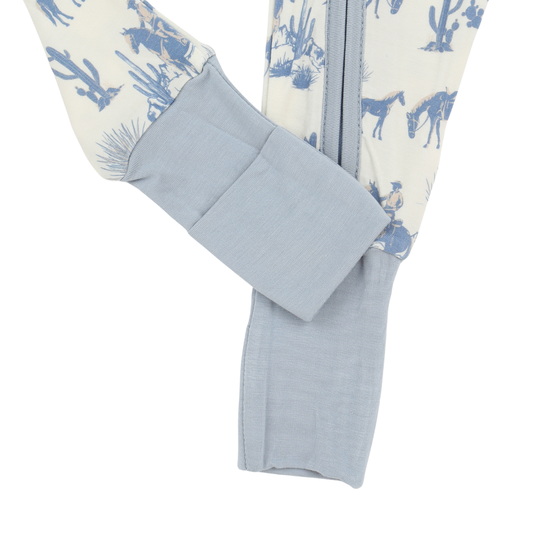 Close-up of a baby onesie with blue cactus pattern on a white background