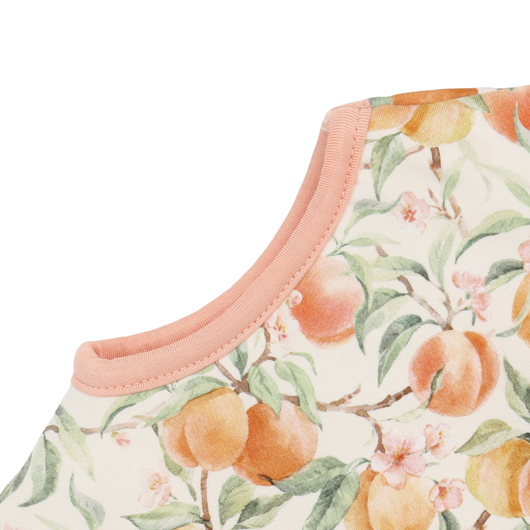 Close-up of a garment with peach and floral pattern on a white background