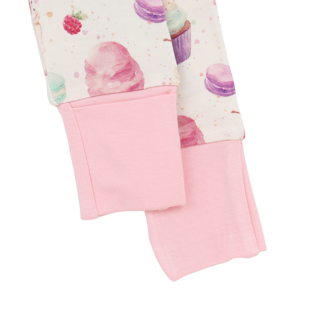 Close-up of a pink fabric with a patterned border on a white background