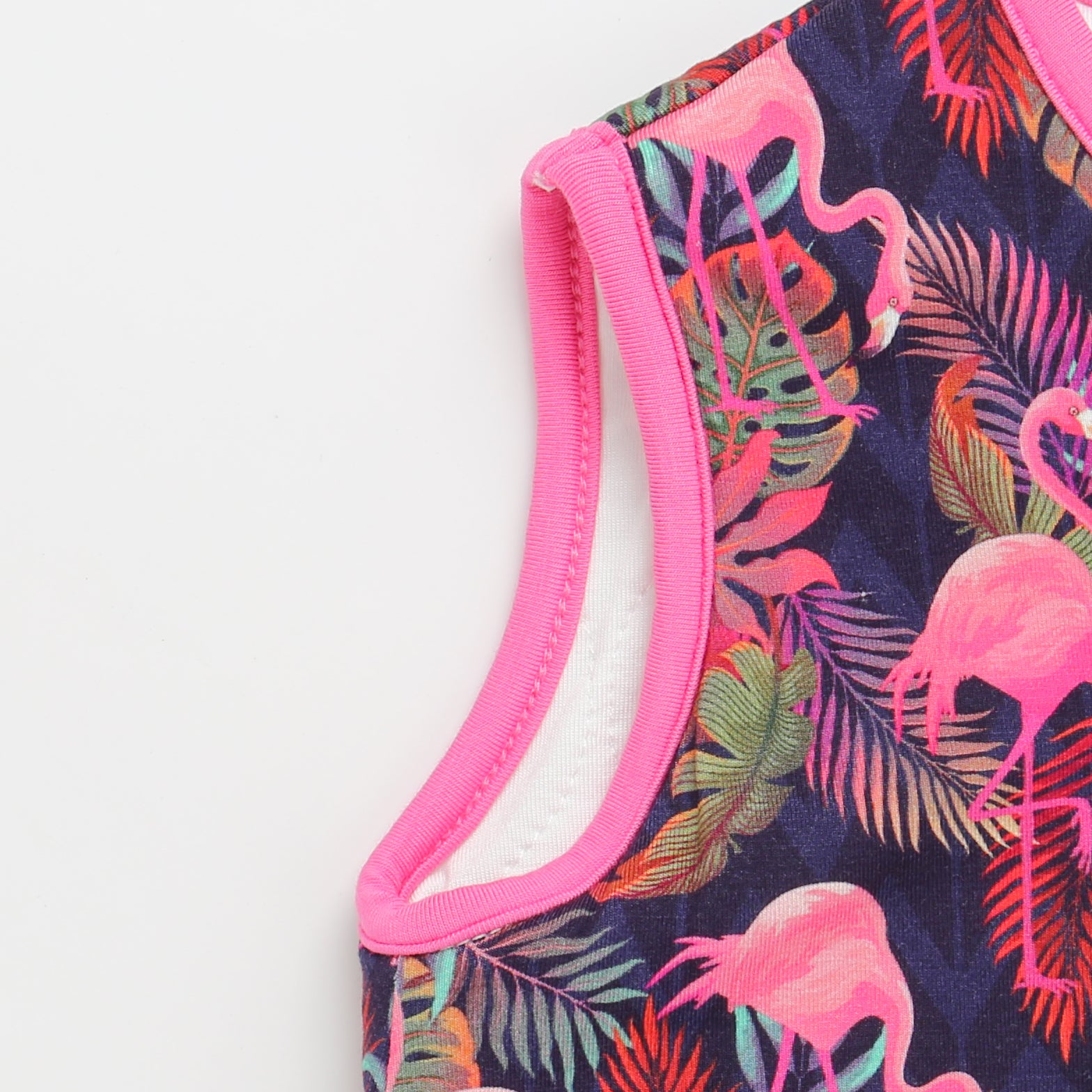 Close-up of a swimsuit with pink flamingo and leaf pattern on a white background