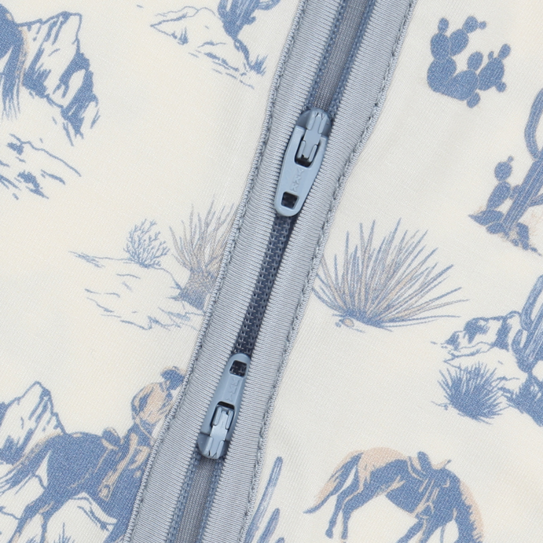 Close-up of a zipper on fabric with blue desert scene print