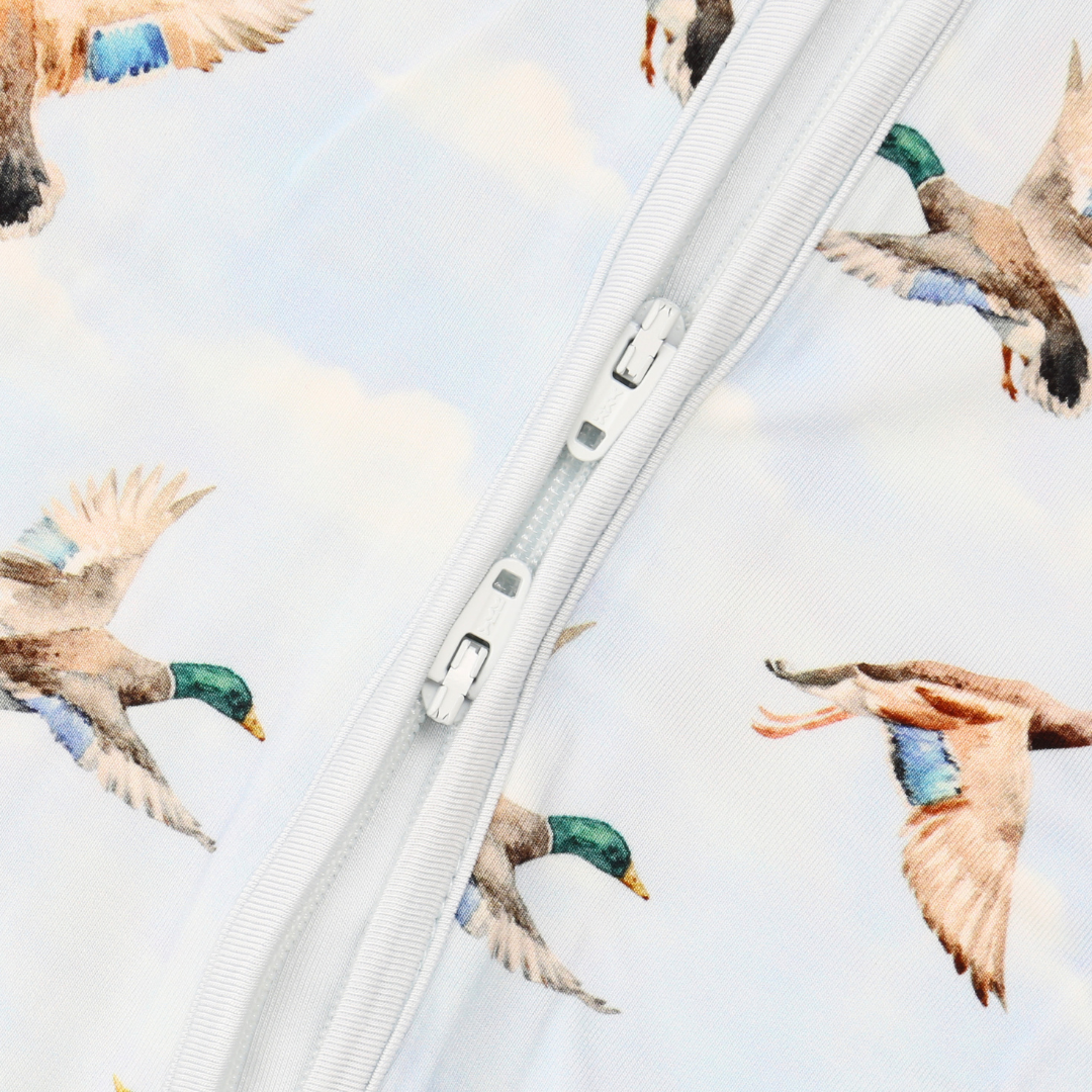Close-up of a zipper with a pattern of flying ducks on a white background