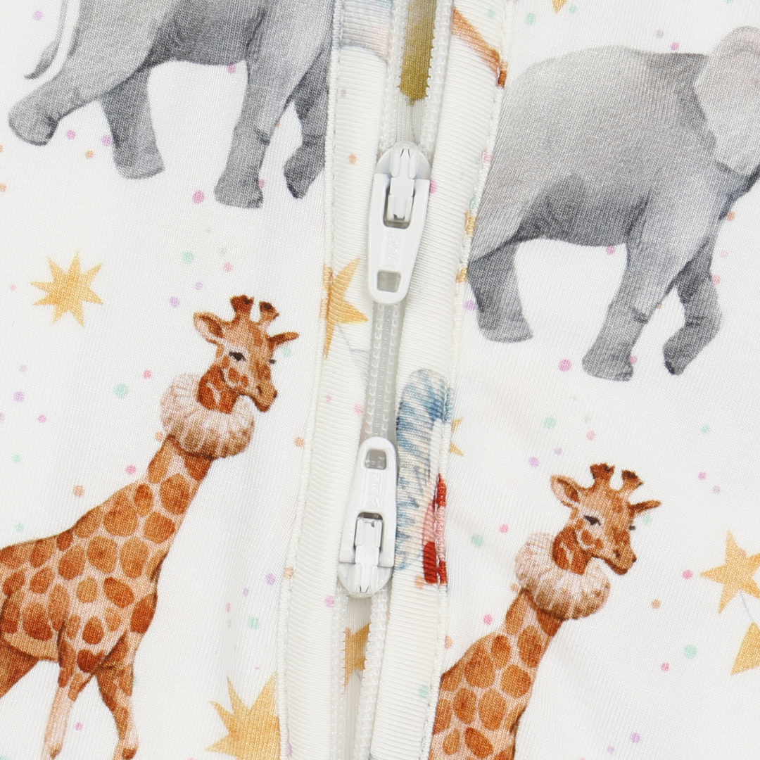 Close-up of a zipper with cartoon giraffes and elephants on a patterned background