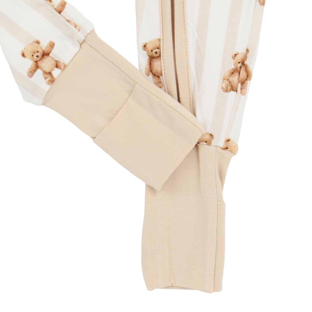 Close-up of beige pants with teddy bear pattern on a white background