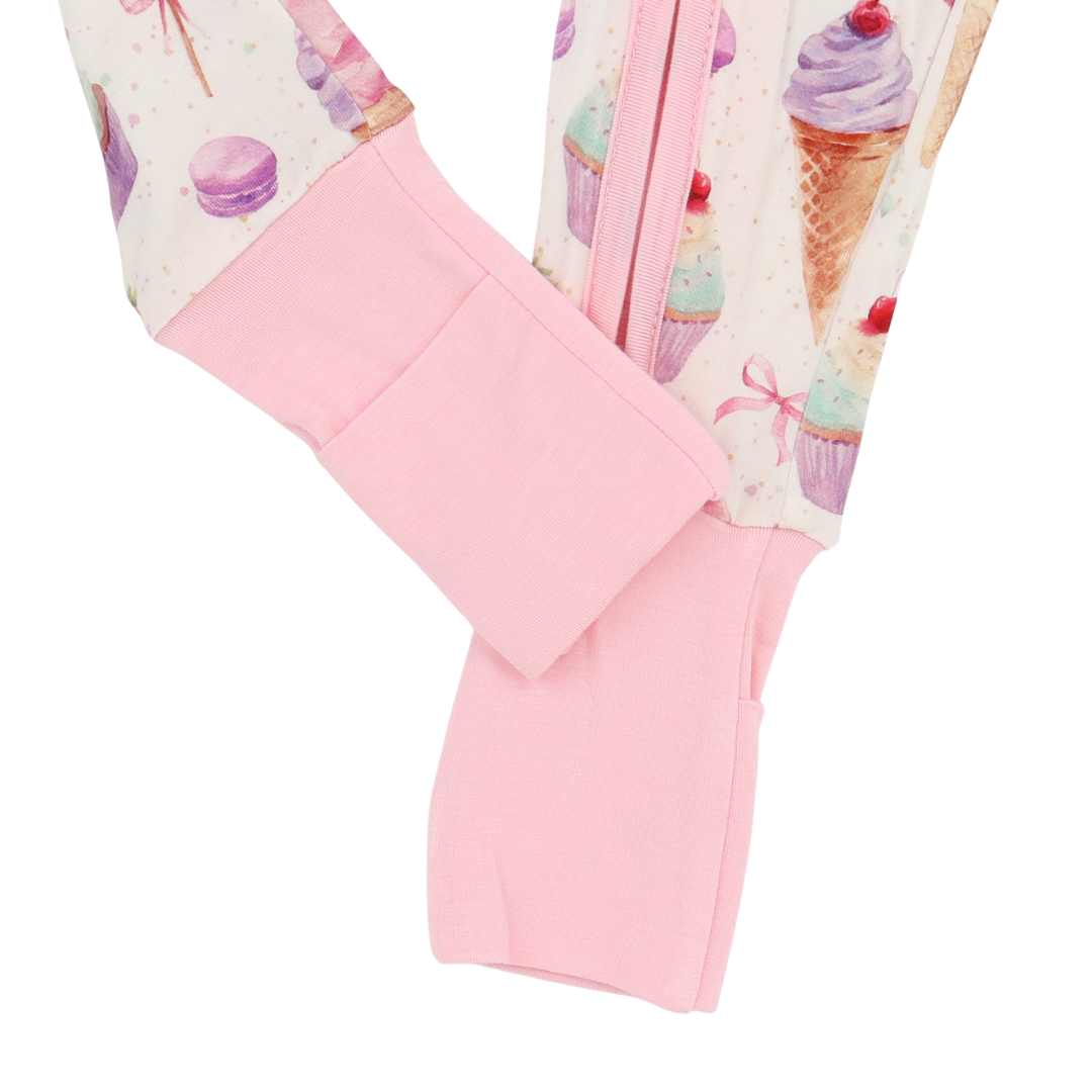 Close-up of pink leggings with ice cream cone and macaron pattern on a white background