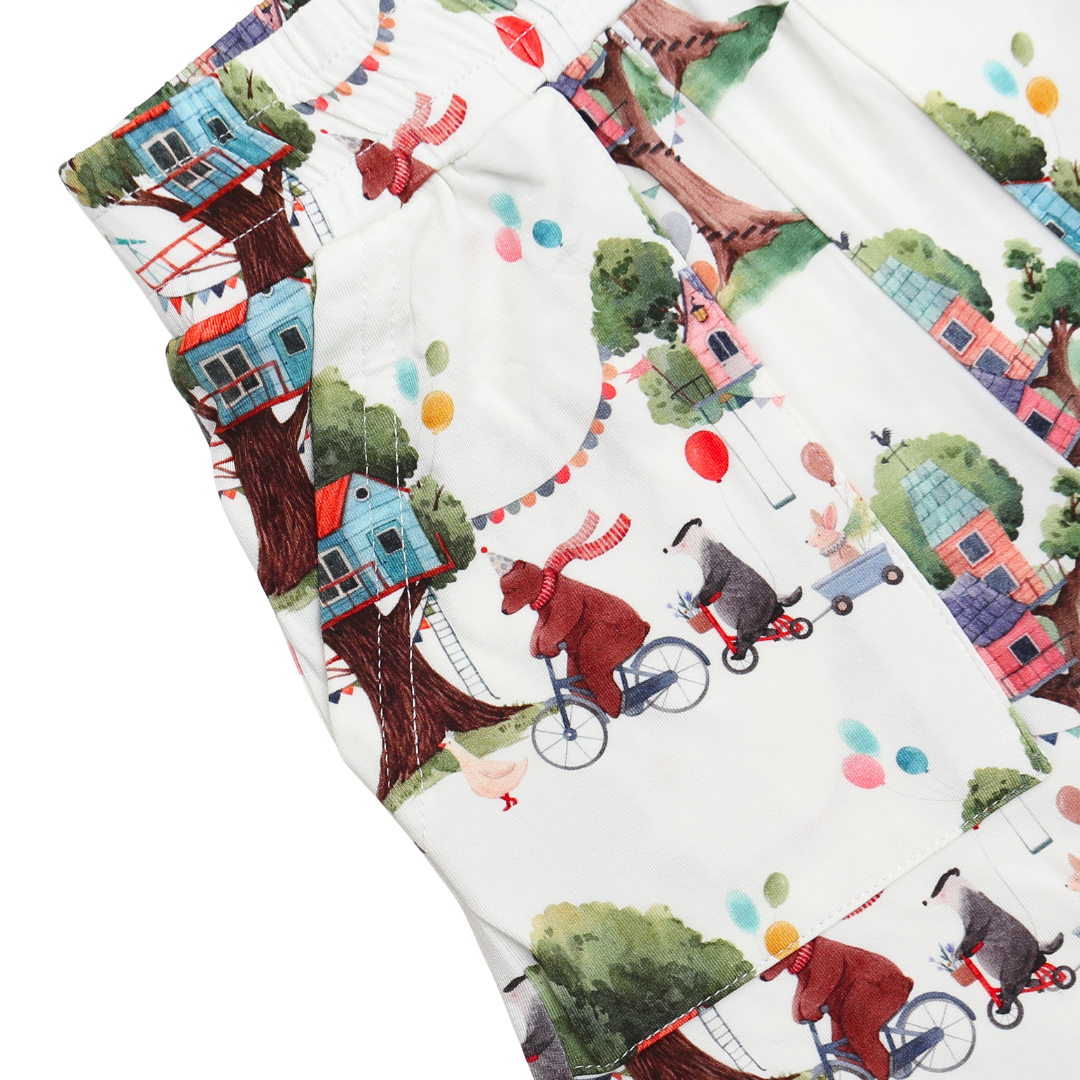 Fabric with children's pattern of bears on tricycles and treehouses.