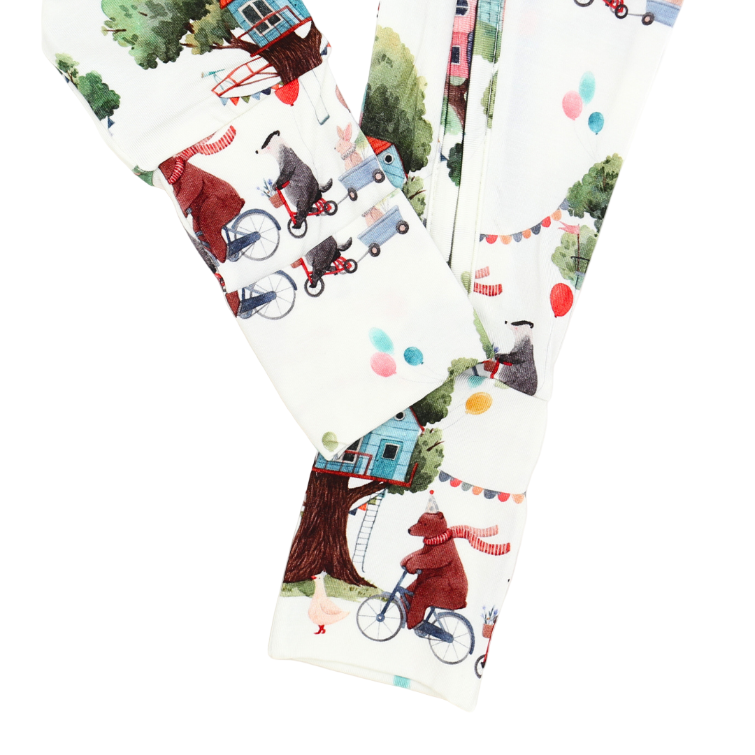 Patterned fabric with children riding bicycles and a treehouse design.