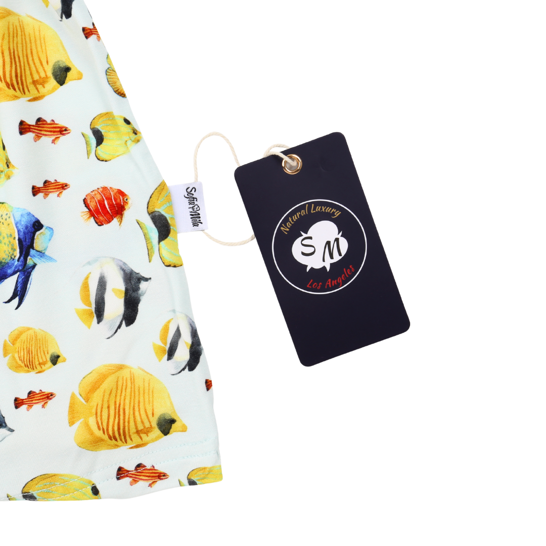 Fabric with fish pattern and a branded tag on a white background
