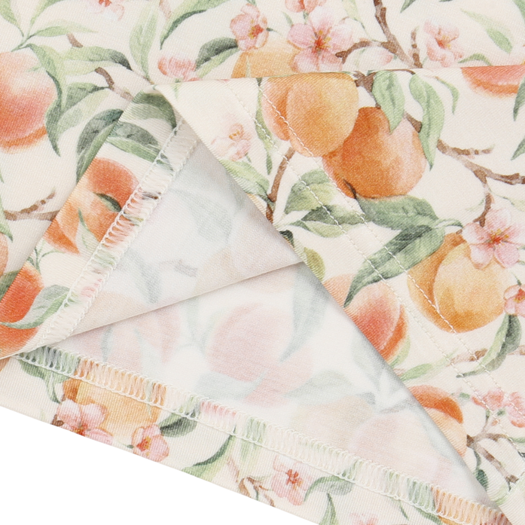 Fabric with peach and floral pattern on a white background