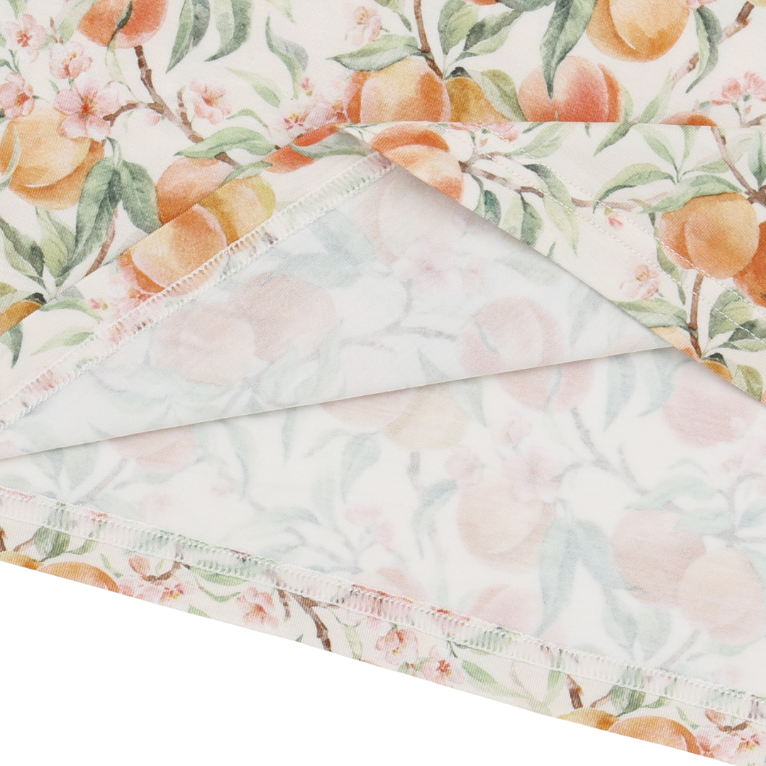 Fabric with peach and floral pattern on a white background