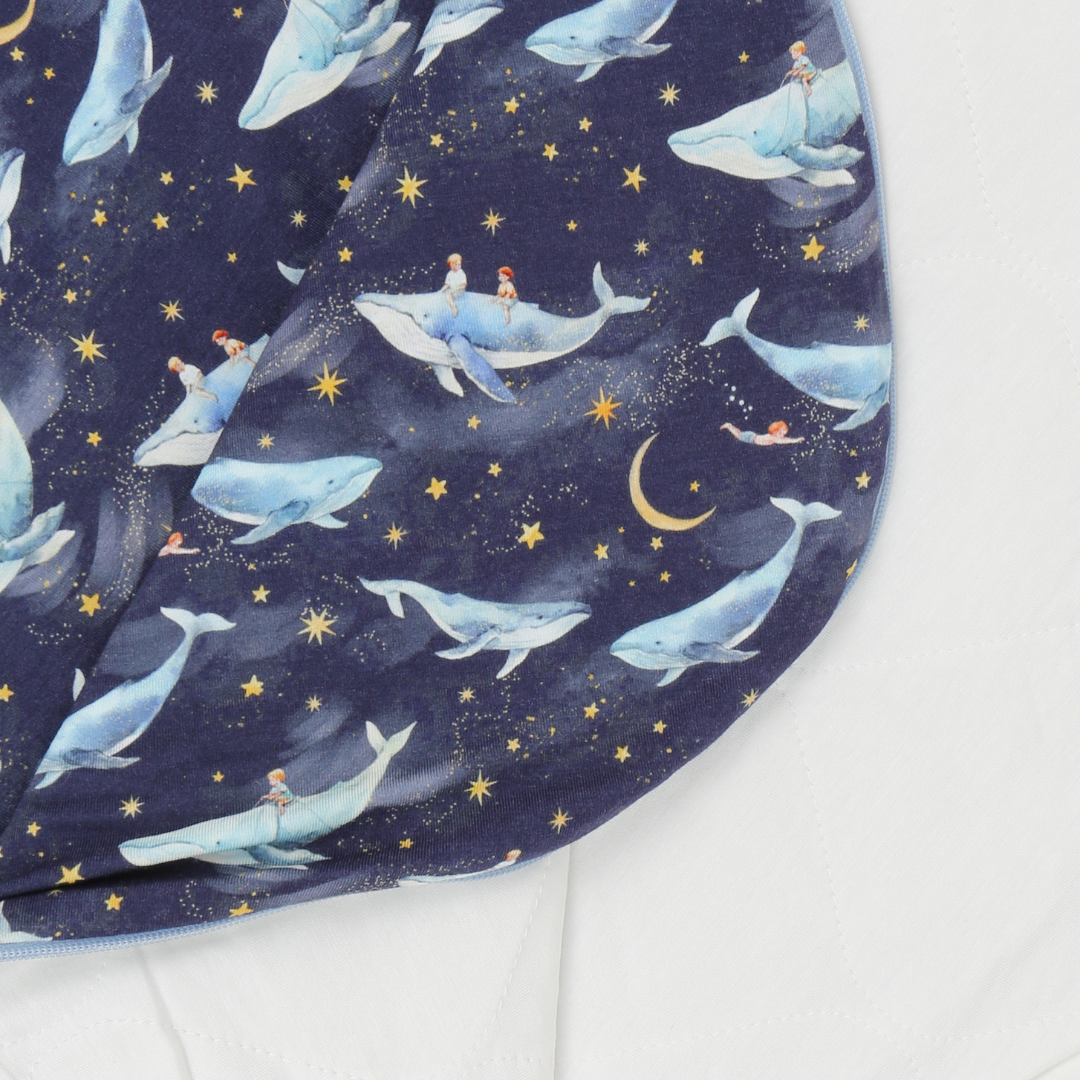 Fabric with whale and mermaid pattern on a blue background