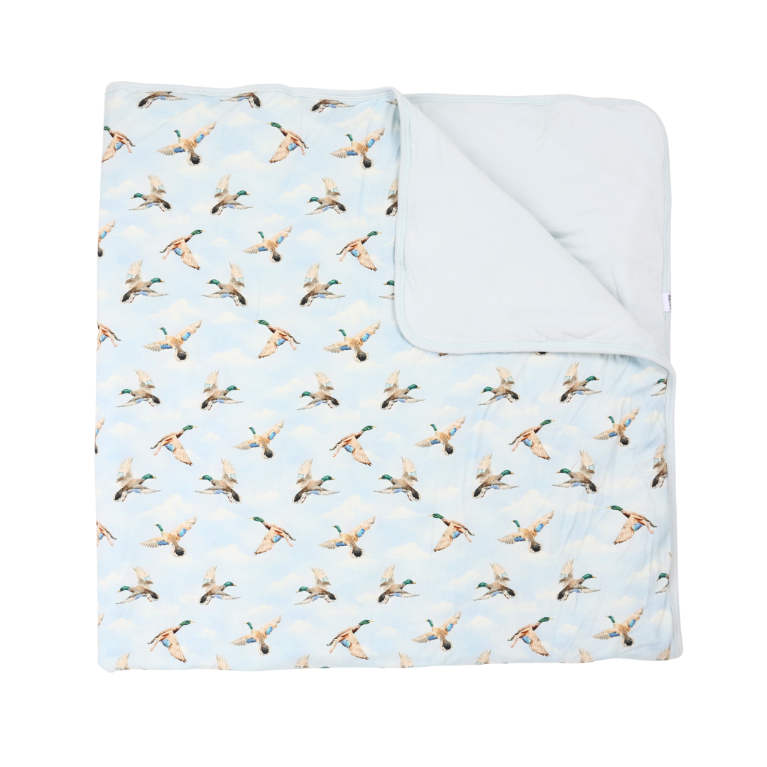 Flannel blanket with duck pattern on a light blue background