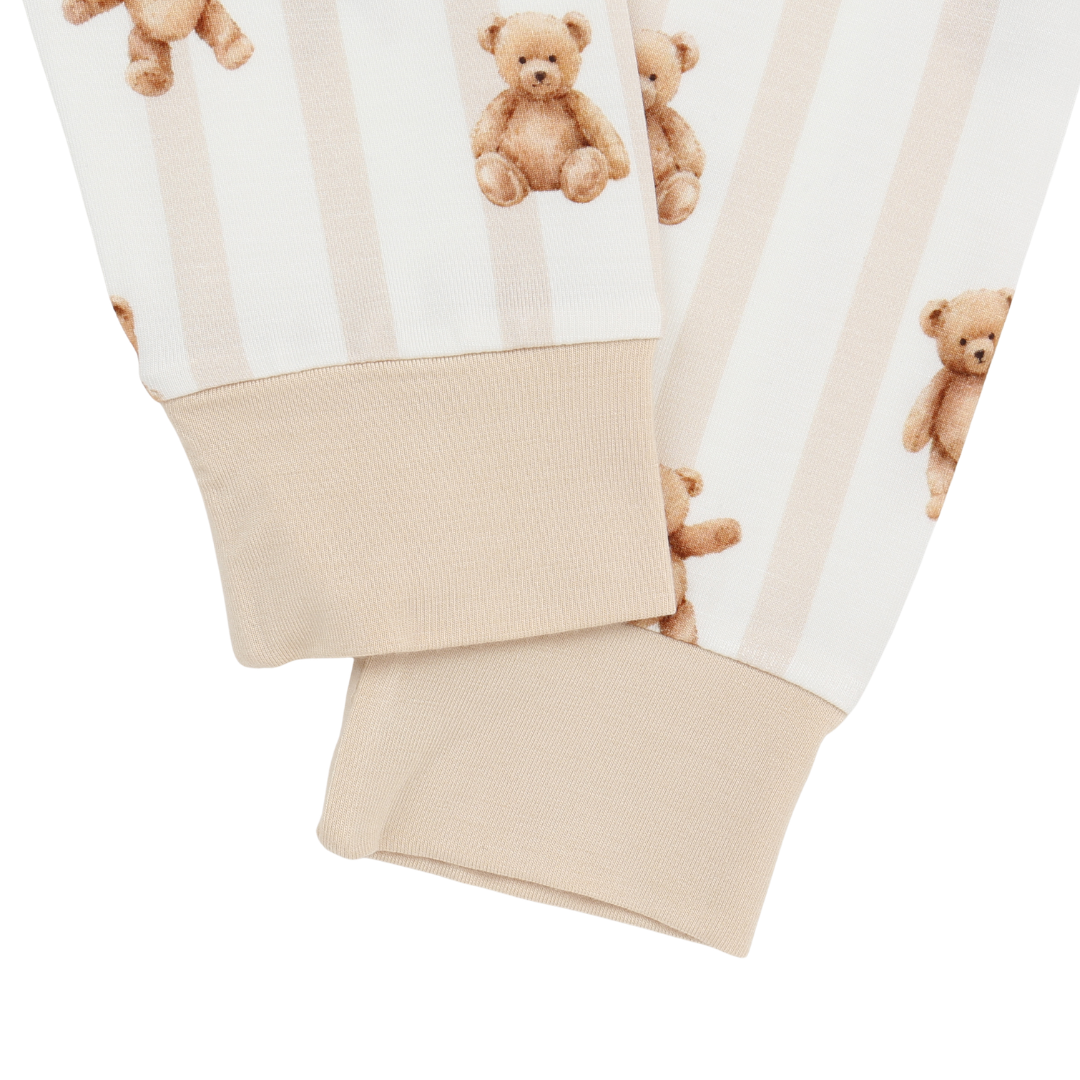 Folded baby romper with teddy bear pattern on a white background