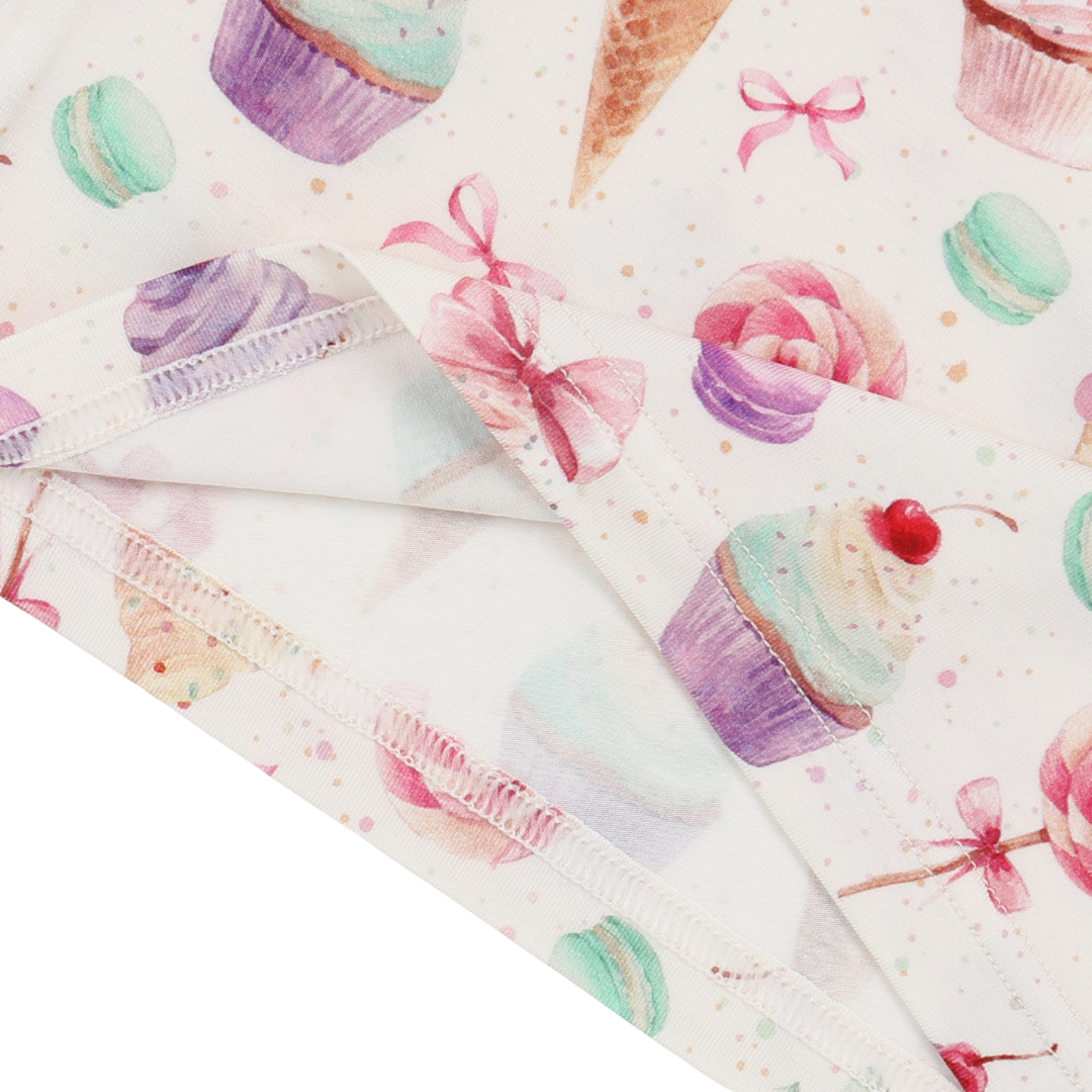 Folded fabric with cupcake and bow pattern on a white background
