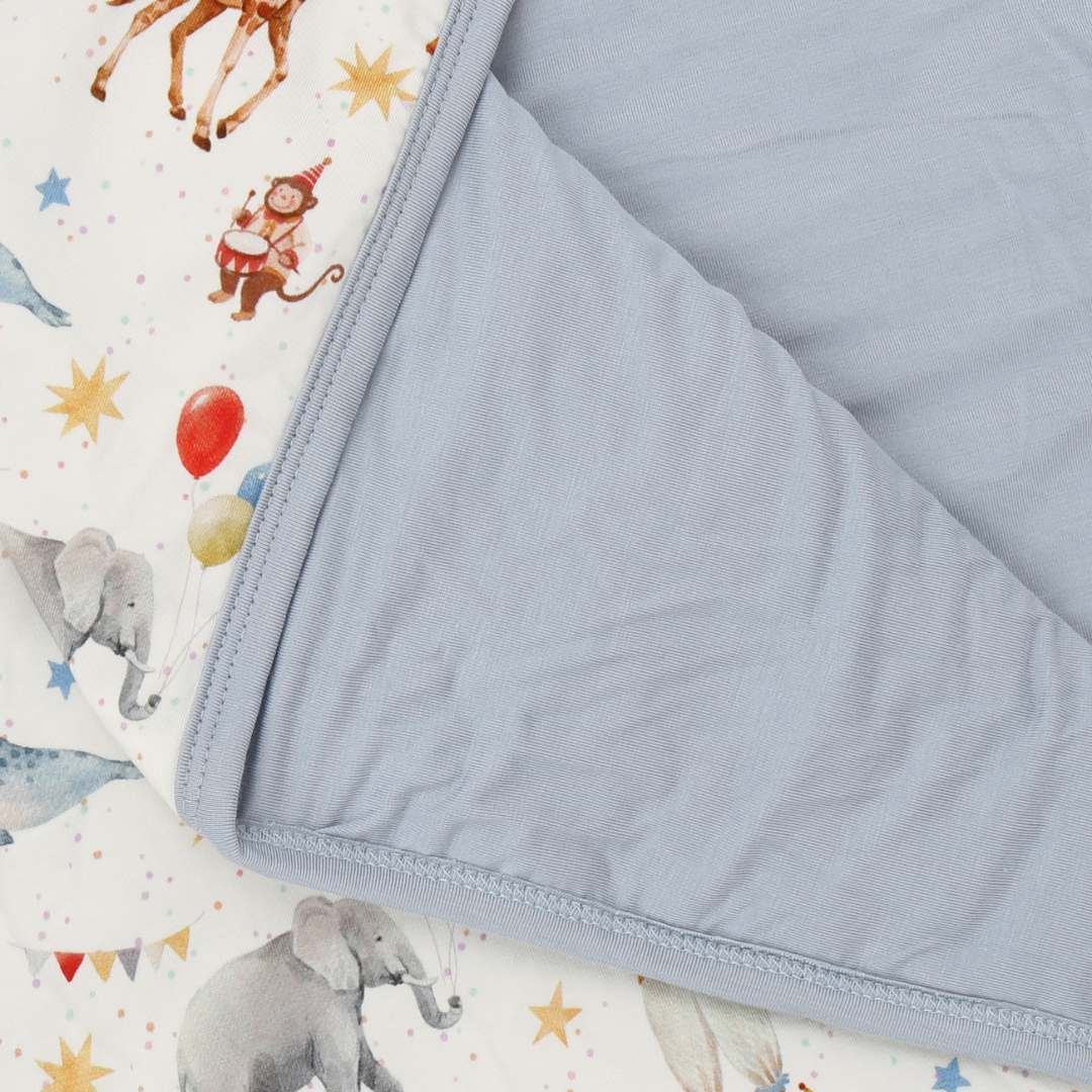 Gray quilted blanket on a fabric with animal prints