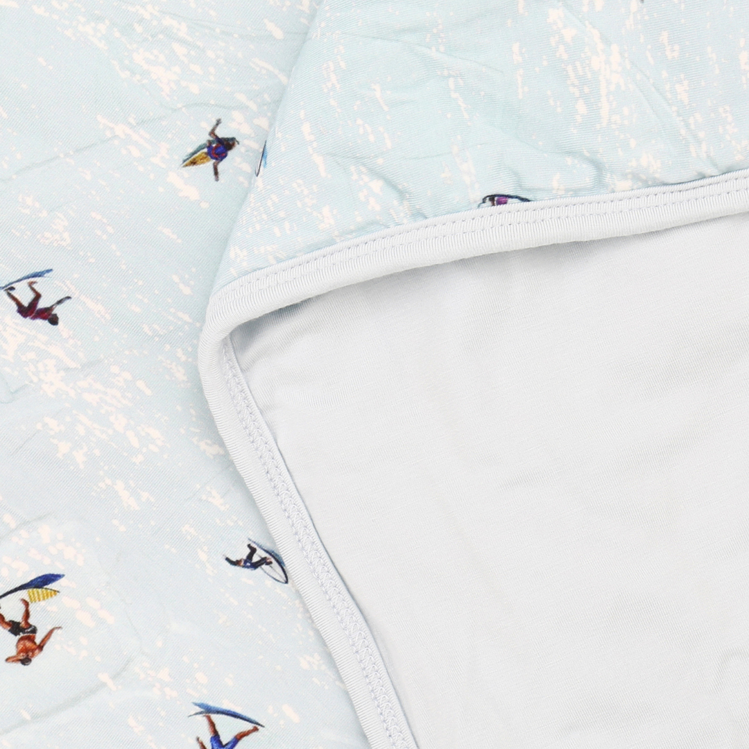 Light blue fabric with embroidered designs of people on surfboards and paddleboards.
