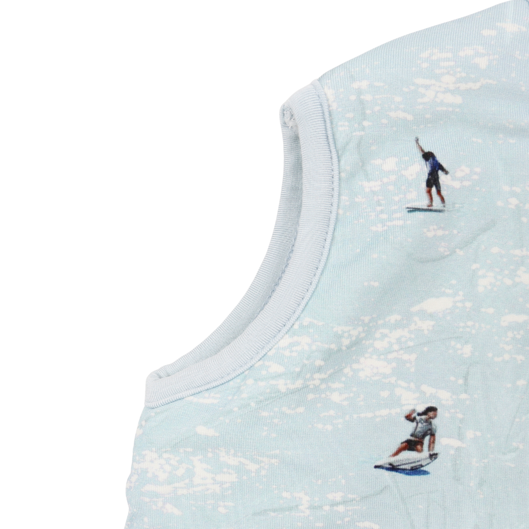 Light blue sleeveless top with embroidered designs of people on surfboards.