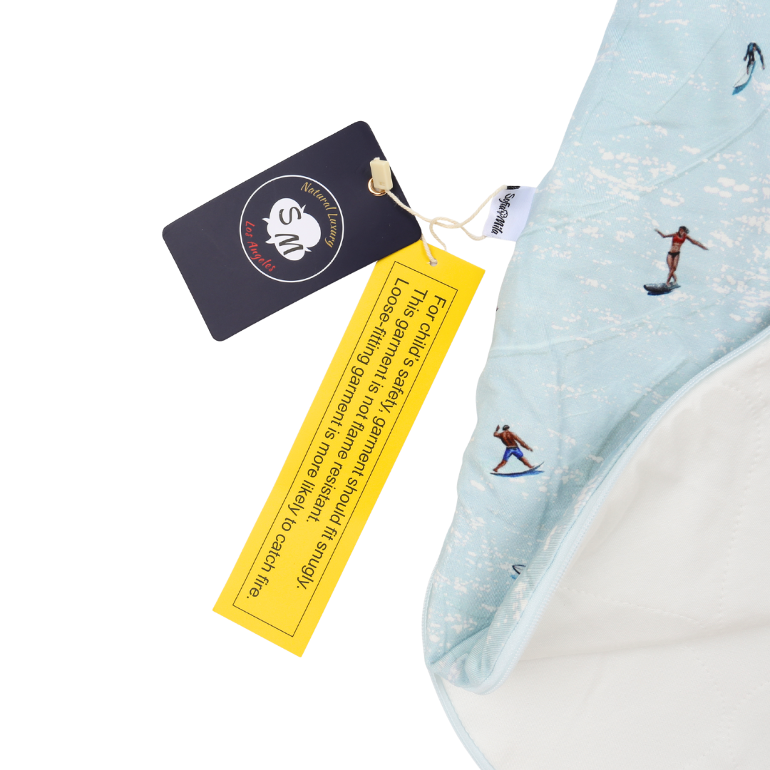 Light blue towel with embroidered designs and tags on a white background