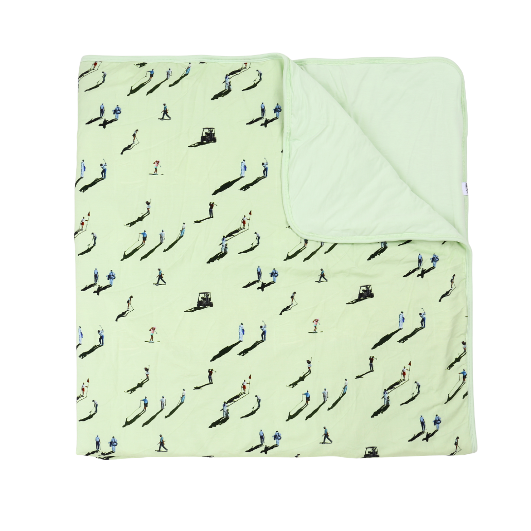 Light green quilt with black and white pattern on a white background