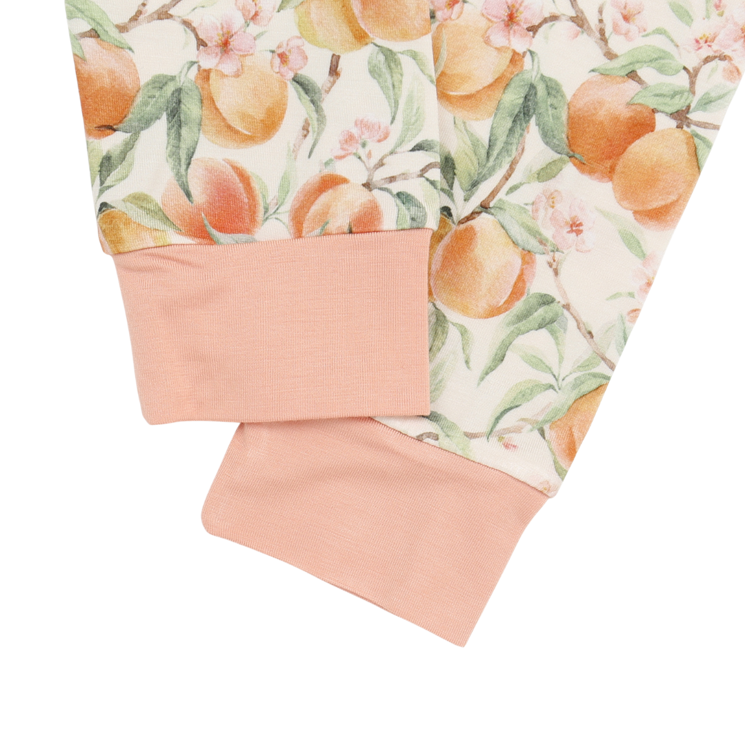 Peach-patterned fabric with a pink border on a white background