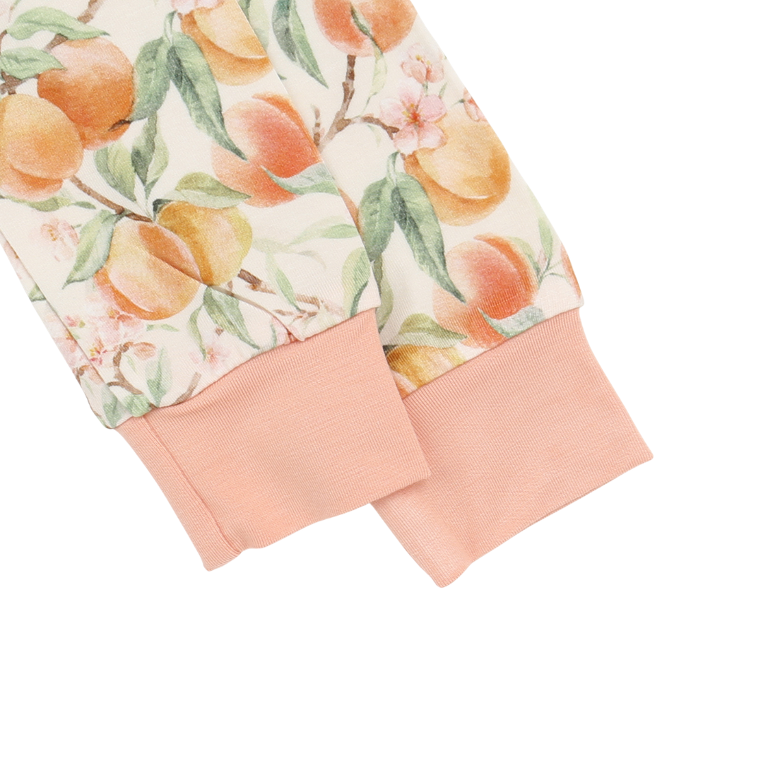 Peach-patterned fabric with pink cuffs on a white background