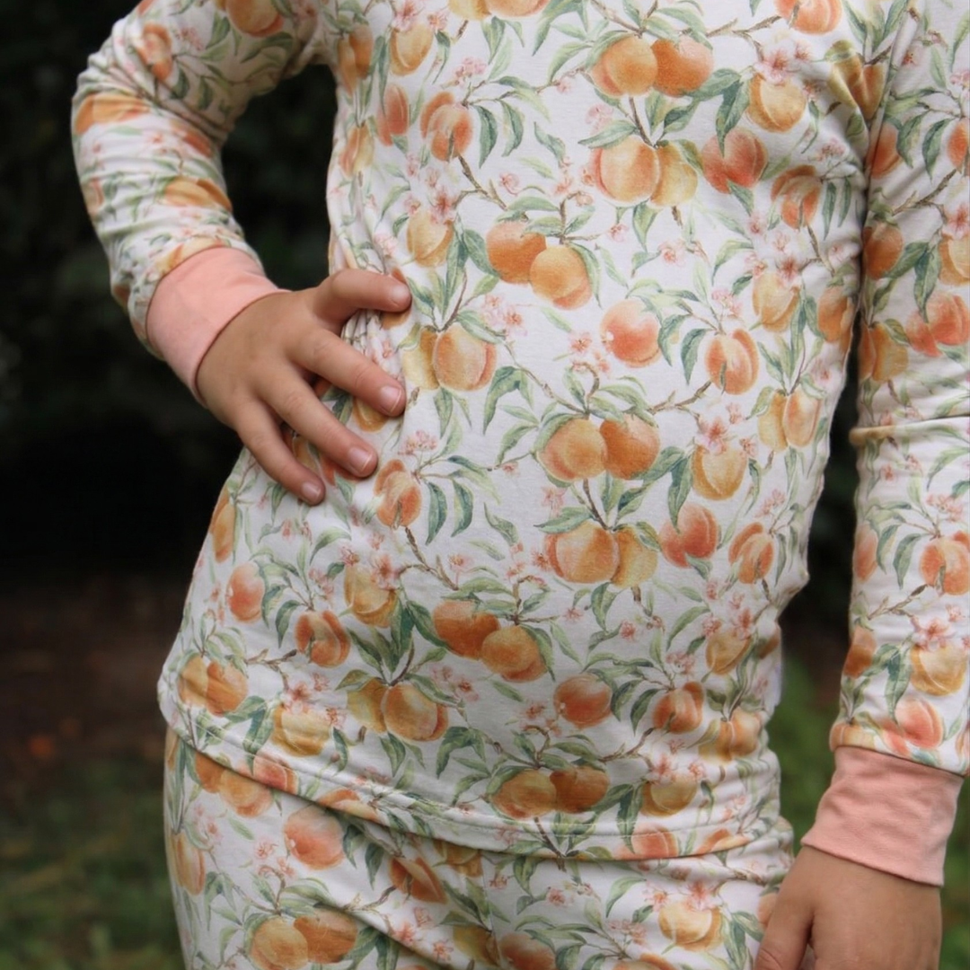 Person wearing a long-sleeve shirt with peach pattern outdoors