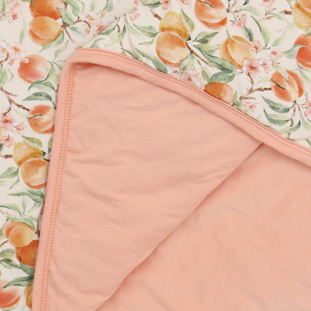 Pink fabric with a floral peach pattern in the background