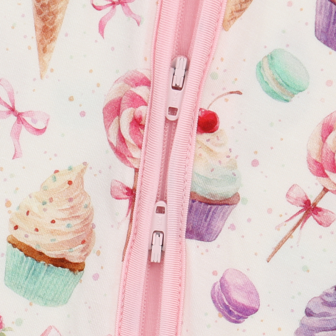 Pink zipper on a background with colorful candy-themed illustrations