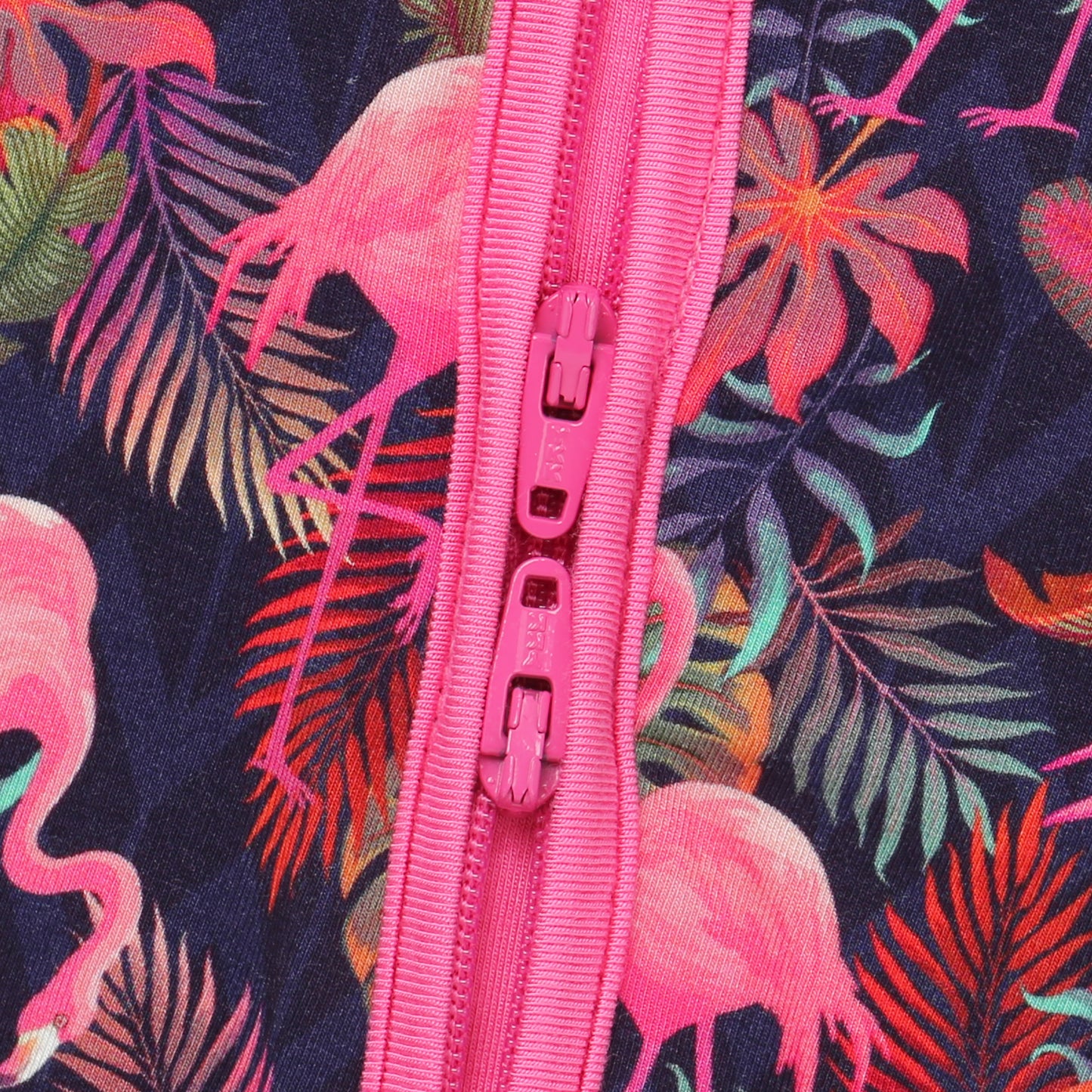 Pink zipper on a fabric with flamingo and leaf patternå