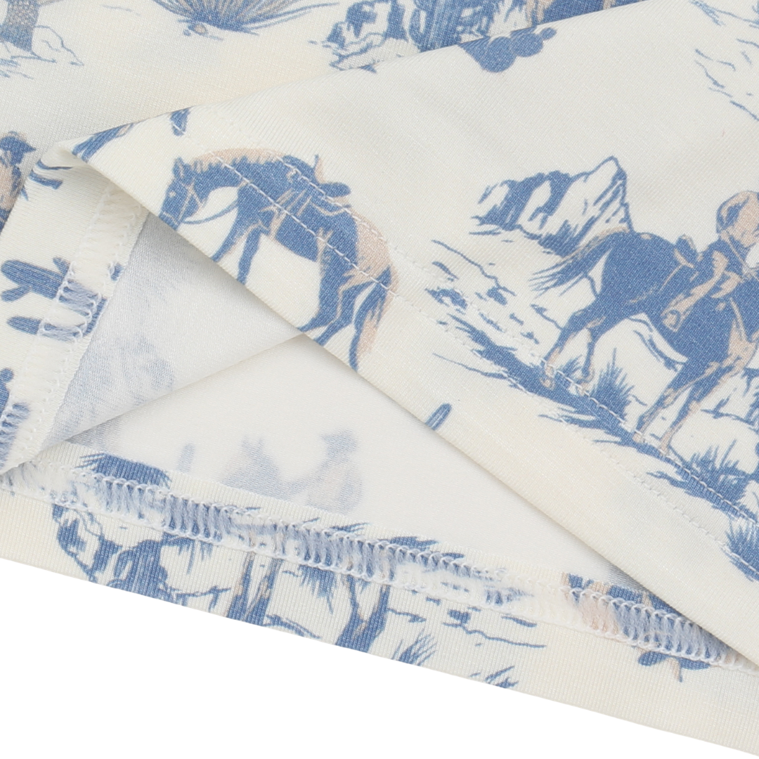 Roll of fabric with blue horse pattern on a white background