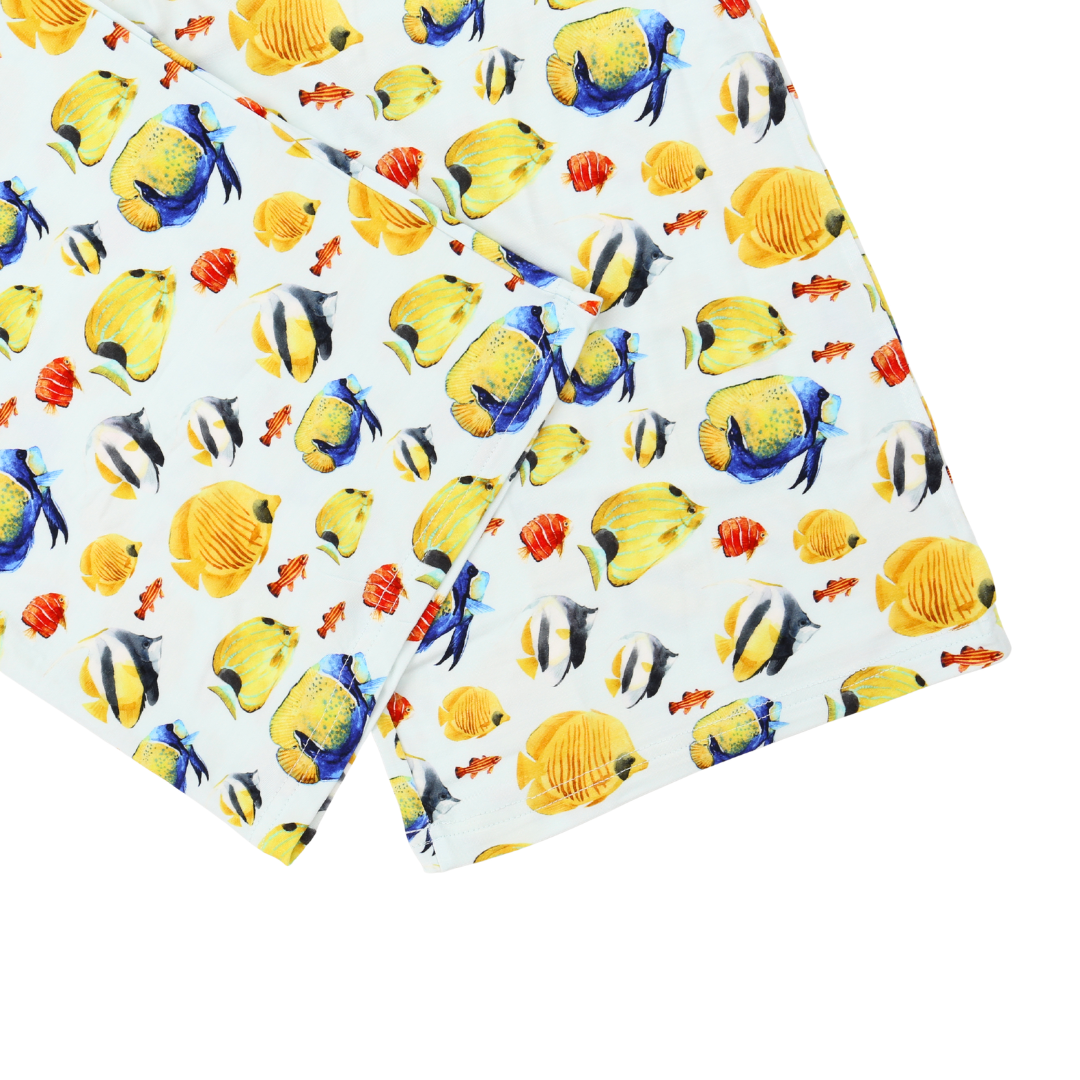 Two folded towels with colorful fish pattern on a white background